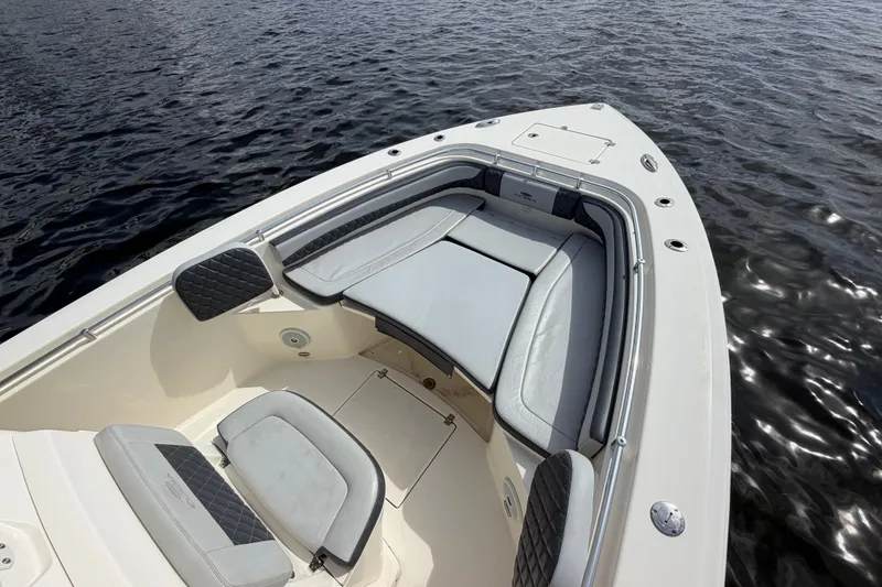 Slide: The Image of 2018 Cobia 301 Center Console boat with cushioned seating on calm water. - 12
