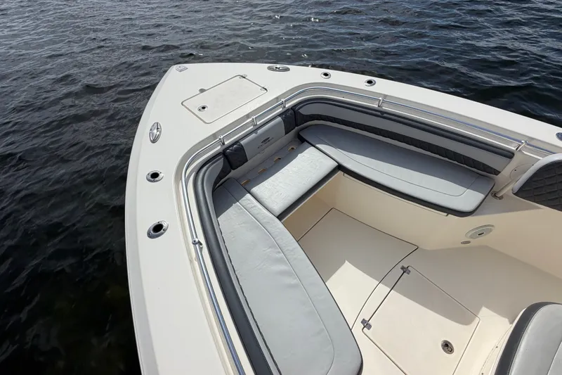 Slide: The Image of 2018 Cobia 301 Center Console boat interior with cushioned seating on water. - 7