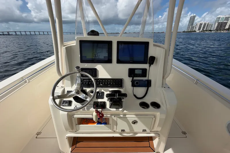 Slide: The Image of 2018 Cobia 301 Center Console boat dashboard with steering wheel and navigation screens. - 26