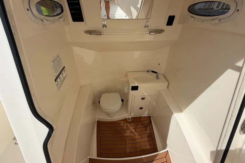 Slide: The Image of 2018 Cobia 301 Center Console boat interior with toilet and sink. - 17