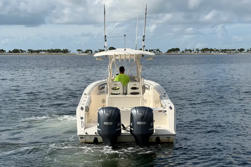 Slide: The Image of 2018 Cobia 301 Center Console boat cruising on open water, rear view. - 5