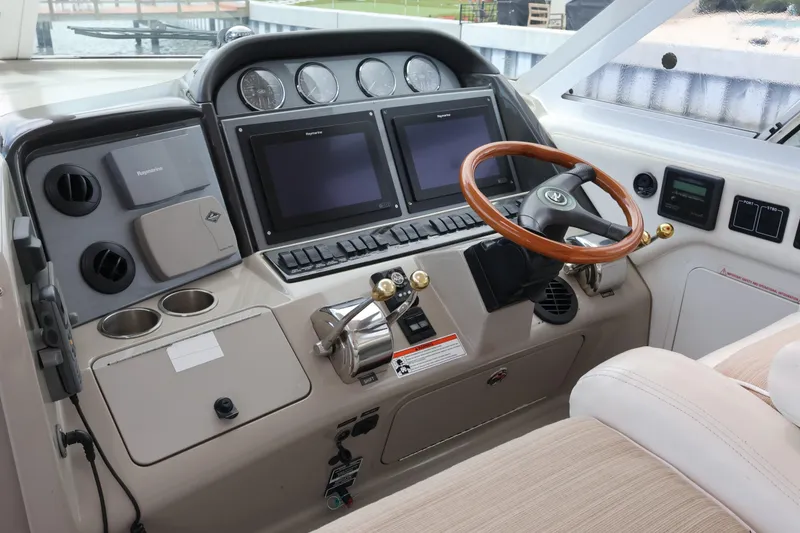 Slide: The Image of 2006 Sea Ray 40 Motor Yacht helm with dual screens and wooden steering wheel. - 21