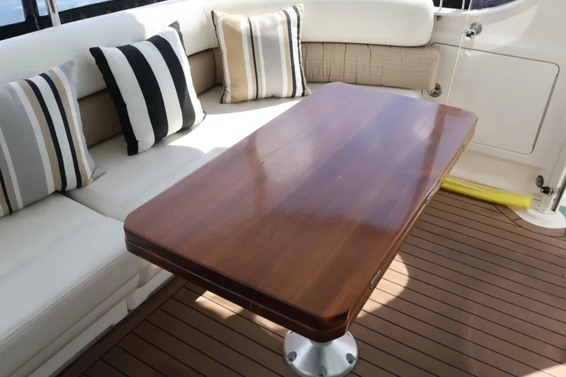 Slide: The Image of Luxurious seating area on 2006 Sea Ray 40 Motor Yacht with striped cushions and wooden table. - 12