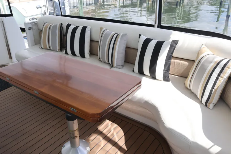 Slide: The Image of Luxurious 2006 Sea Ray 40 Motor Yacht interior with striped cushions and wooden table. - 11