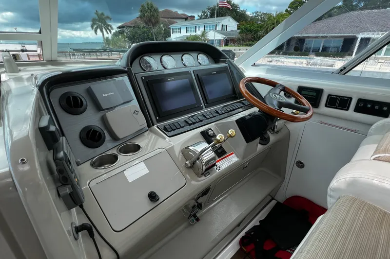 Slide: The Image of 2006 Sea Ray 40 Motor Yacht helm with dual screens and wooden steering wheel. - 22