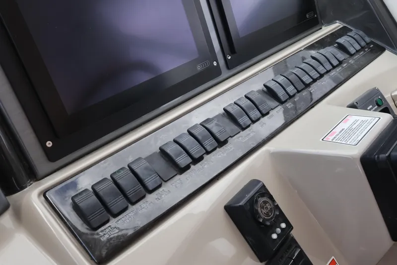 Slide: The Image of Control panel of a 2006 Sea Ray 40 Motor Yacht with switches and screens. - 24