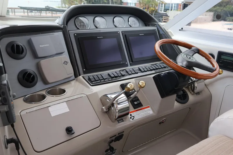 Slide: The Image of 2006 Sea Ray 40 Motor Yacht helm with dual screens and wooden steering wheel. - 23