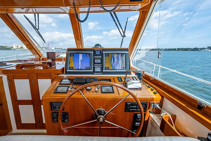 Slide: The Image of Helm of 2001 Grand Banks 49 Eastbay HX yacht with navigation screens and wooden steering wheel. - 34