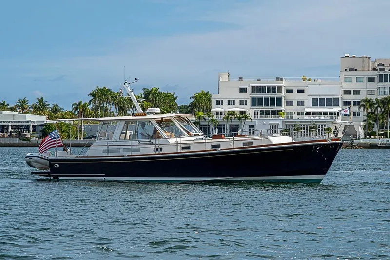 The Image of 2001 Grand Banks 49 Eastbay HX yacht cruising near modern waterfront buildings. - 0