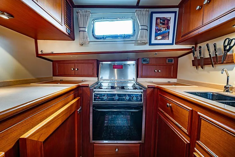 Slide: The Image of Luxurious 2001 Grand Banks 49 Eastbay HX yacht kitchen with wood cabinetry and modern appliances. - 38
