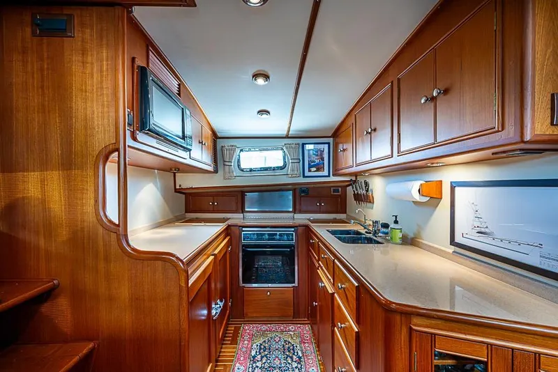 Slide: The Image of Luxurious 2001 Grand Banks 49 Eastbay HX yacht kitchen with wood cabinetry and modern appliances. - 37