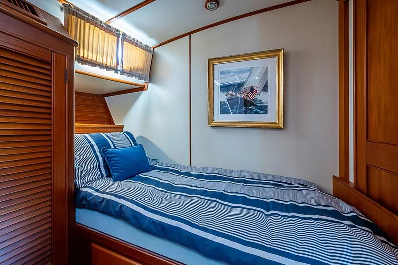Slide: The Image of Cozy cabin interior of 2001 Grand Banks 49 Eastbay HX with striped bedding and nautical decor. - 50