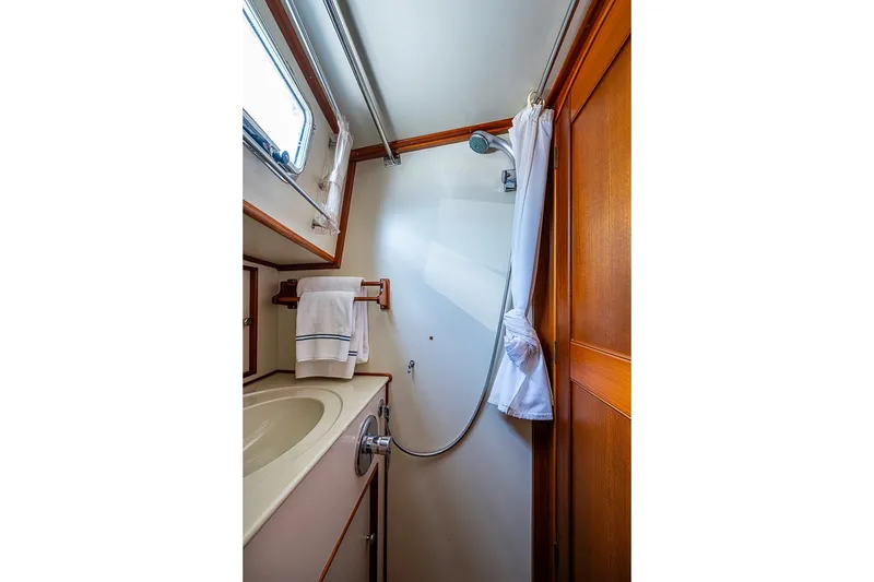 Slide: The Image of 2001 Grand Banks 49 Eastbay HX yacht bathroom with shower, sink, and wooden accents. - 46