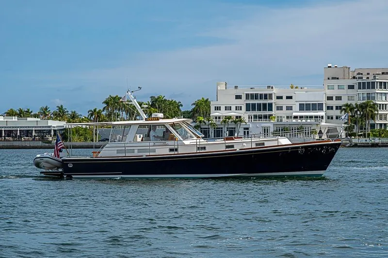 Slide: The Image of 2001 Grand Banks 49 Eastbay HX yacht cruising near waterfront buildings. - 52
