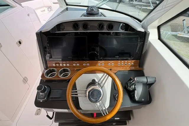 Slide: The Image of 2027 Tiara Yachts 34 LX helm with wooden steering wheel and modern controls. - 23