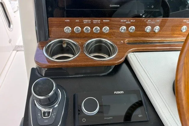 Slide: The Image of Control panel of 2027 Tiara Yachts 34 LX with cup holders and navigation controls. - 24