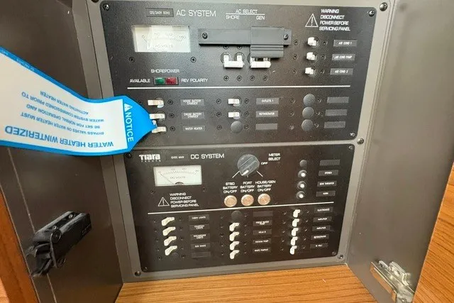 Slide: The Image of Electrical control panel of 2027 Tiara Yachts 34 LX, featuring AC and DC systems. - 16
