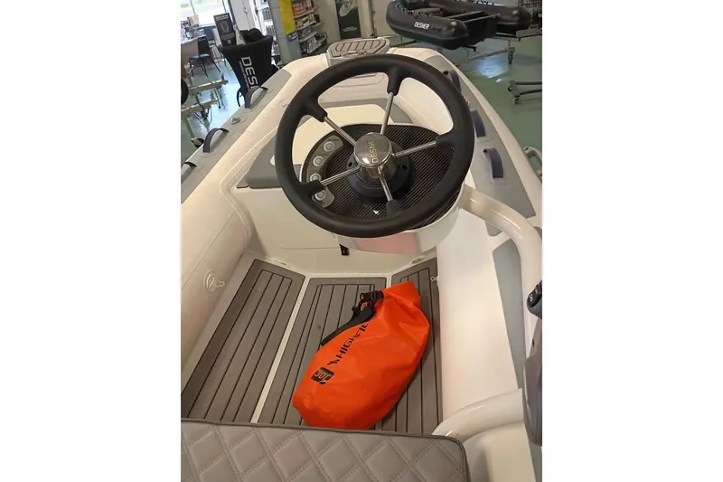 The Image of 2024 Highfeild CL 340 boat interior with steering wheel and orange bag on deck. - 1