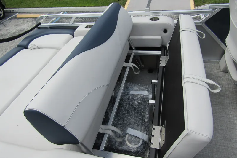 Slide: The Image of 2026 Tahoe Pontoon LTZ Versatile Rear Bench with storage compartment, featuring white and navy upholstery. - 25