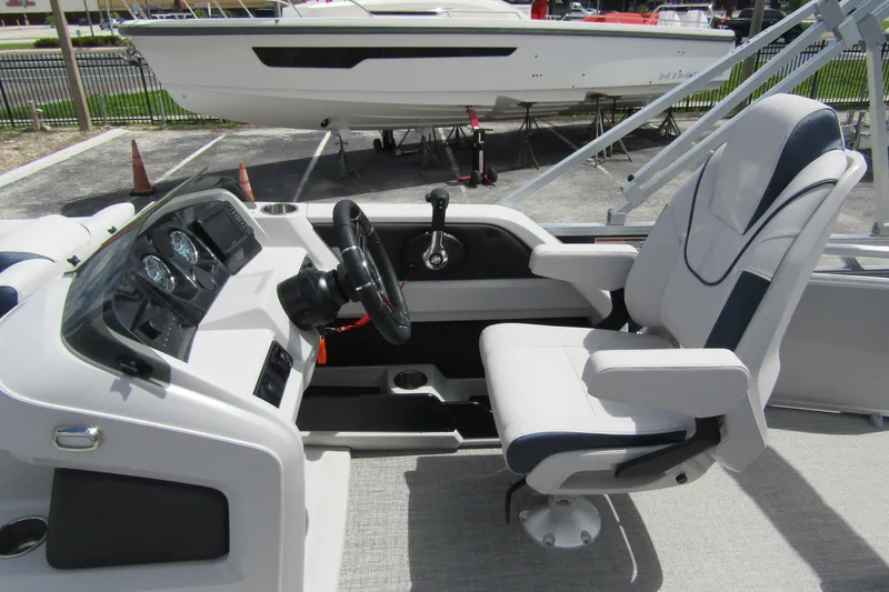Slide: The Image of 2026 Tahoe Pontoon LTZ Versatile Rear Bench Wind Shield 23 interior with captain's chair and dashboard. - 15