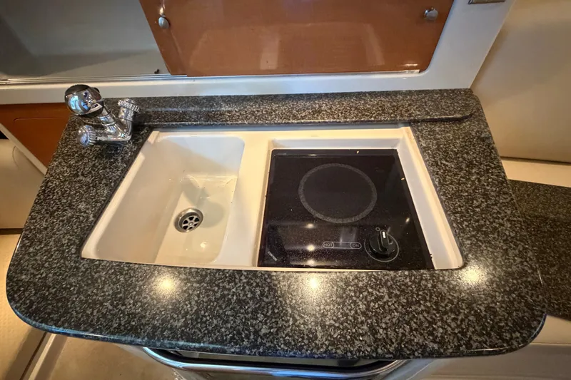 Slide: The Image of 2008 Chaparral Signature 270 kitchen area with granite countertop, sink, and electric stove. - 34