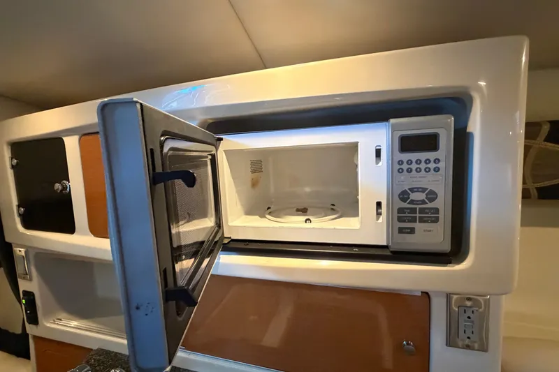Slide: The Image of 2008 Chaparral Signature 270 interior with open microwave in kitchenette area. - 35