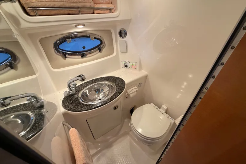 Slide: The Image of 2008 Chaparral Signature 270 bathroom with sink, toilet, and porthole window. - 40