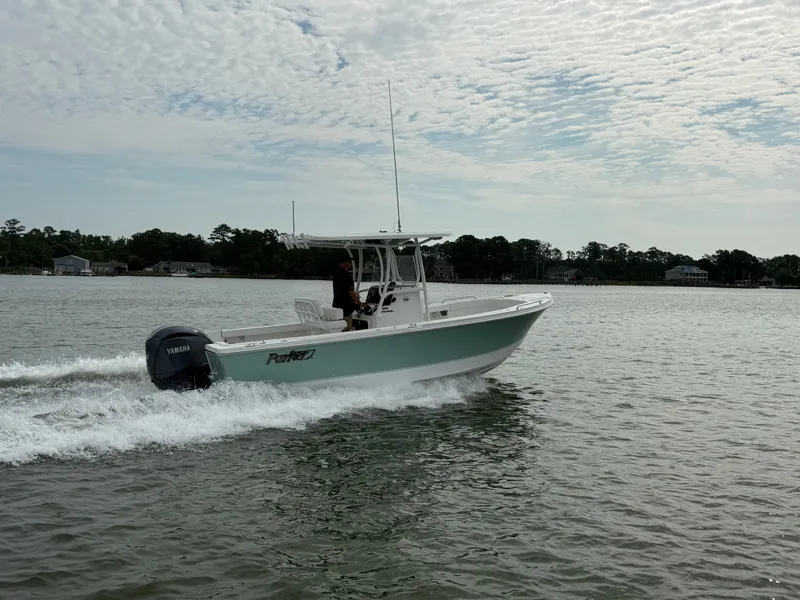 Slide: The Image of A 2026 Parker 230 Coastal Elite boat speeds across the water under a cloudy sky. - 3