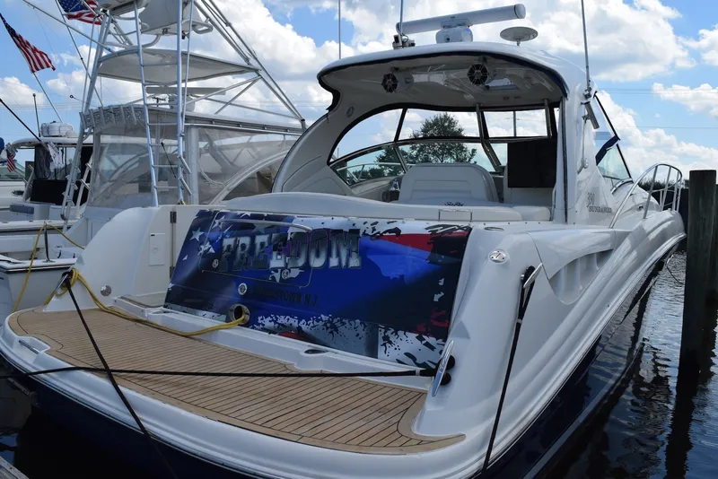 Slide: The Image of 2004 Sea Ray 390 Sundancer yacht docked, featuring sleek design and spacious deck. - 2