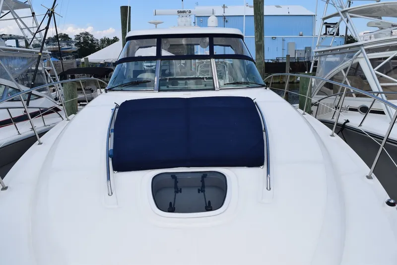 Slide: The Image of 2004 Sea Ray 390 Sundancer yacht docked, featuring sleek design and spacious deck. - 9