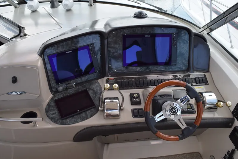 Slide: The Image of Cockpit of 2004 Sea Ray 390 Sundancer with dual Simrad displays and wooden steering wheel. - 19
