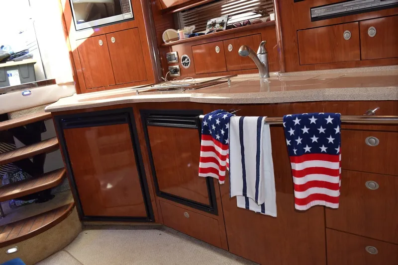 Slide: The Image of 2004 Sea Ray 390 Sundancer interior with American flag towels in the kitchen area. - 33