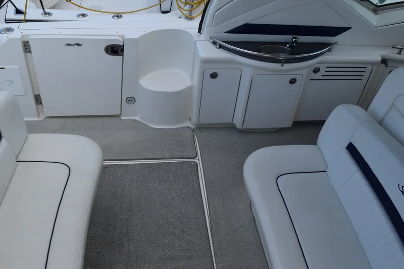 Slide: The Image of 2004 Sea Ray 390 Sundancer cockpit with seating, sink, and storage cabinets. - 12