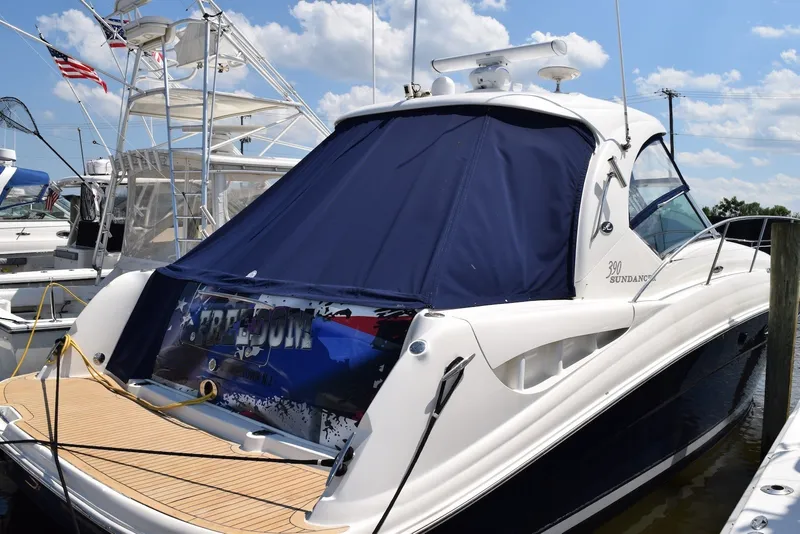 Slide: The Image of 2004 Sea Ray 390 Sundancer yacht docked with blue cover and American flag. - 1