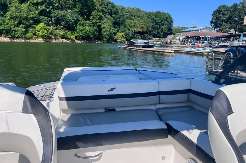 Slide: The Image of 2023 Starcraft SVX 210 IO boat interior at a scenic lakeside marina. - 11