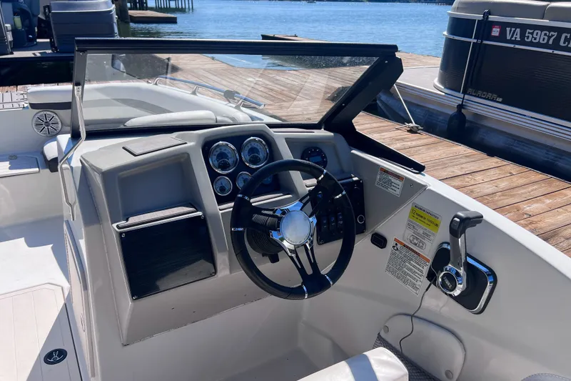 Slide: The Image of Cockpit of 2023 Starcraft SVX 210 IO boat, featuring steering wheel and control panel. - 8