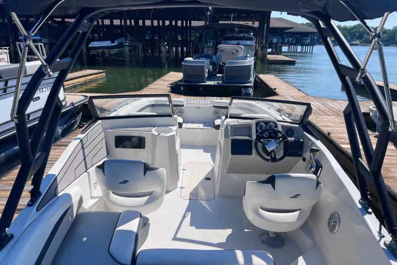 Slide: The Image of 2023 Starcraft SVX 210 IO boat interior at dock, featuring modern seating and controls. - 13