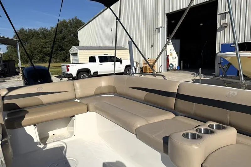 Slide: The Image of 2022 Hurricane SunDeck Sport 201 OB boat interior with beige seating and cup holders. - 19