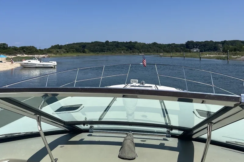 Slide: The Image of 1997 Sea Ray Sundancer 400 cruising on a serene river with scenic shoreline views. - 13
