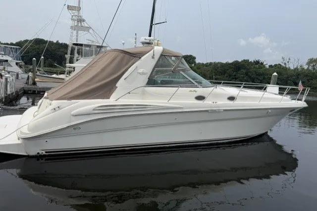 Slide: The Image of 1997 Sea Ray Sundancer 400 yacht docked in a marina, featuring sleek design and beige canopy. - 7
