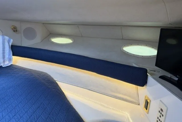 Slide: The Image of Interior cabin of 1997 Sea Ray Sundancer 400 with blue bedding and porthole windows. - 25