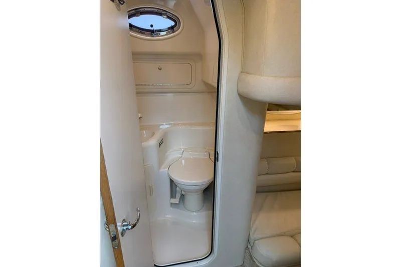Slide: The Image of 1997 Sea Ray Sundancer 400 yacht bathroom interior with compact design and porthole window. - 28