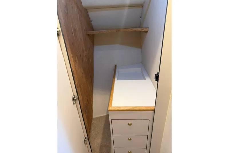 Slide: The Image of 1997 Sea Ray Sundancer 400 interior with wooden cabinetry and built-in storage drawers. - 32