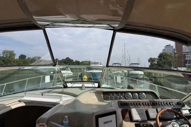 Slide: The Image of 1997 Sea Ray Sundancer 400 helm view, showcasing dashboard and marina backdrop. - 14