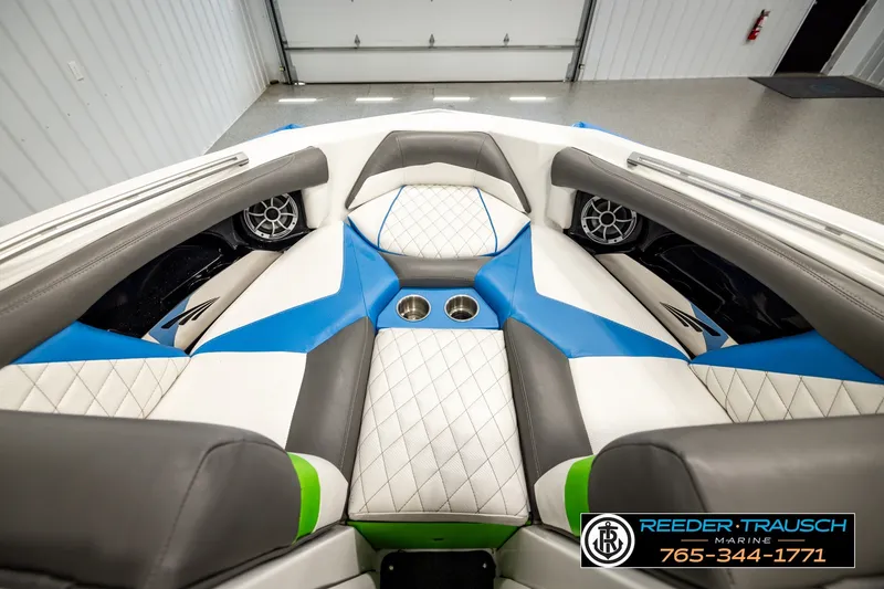 Slide: The Image of Interior of 2013 Tigé RZR boat with blue and white seating, cup holders, and speakers. - 25