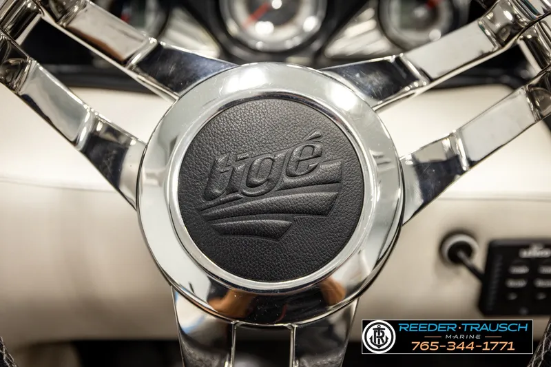 Slide: The Image of Steering wheel of a 2013 Tigé RZR boat with chrome accents and logo. - 31