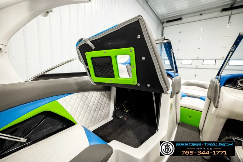 Slide: The Image of Interior of a 2013 Tigé RZR boat with vibrant upholstery and storage compartment. - 28