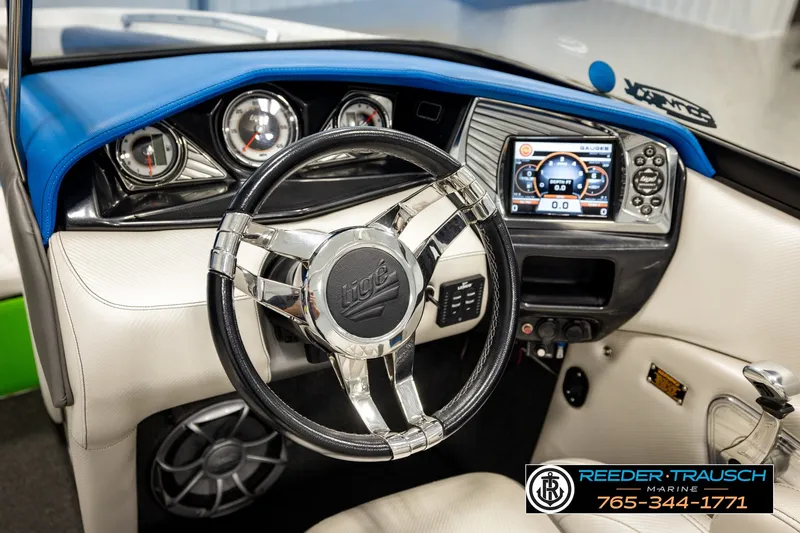 Slide: The Image of Interior view of 2013 Tigé RZR boat dashboard with steering wheel and digital display. - 30