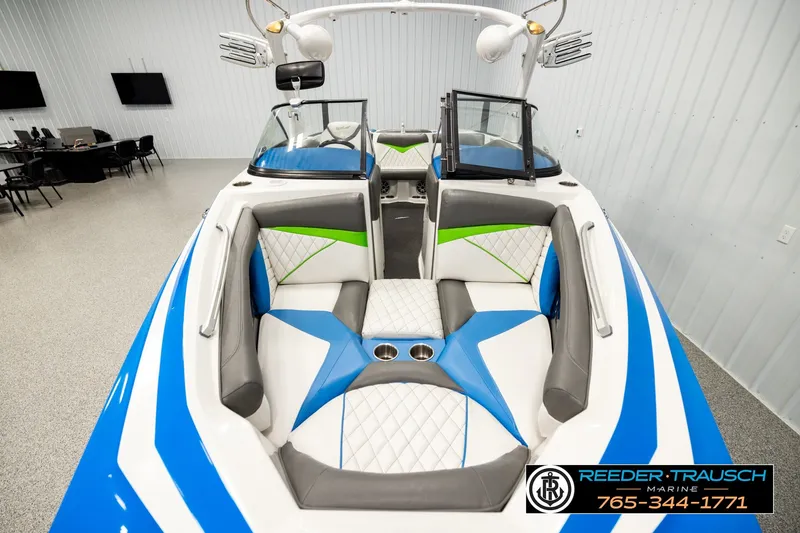 Slide: The Image of 2013 Tigé RZR boat interior with blue, white, and green accents in showroom. - 15