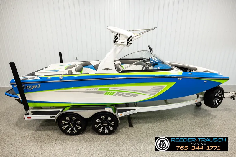 The Image of 2013 Tigé RZR boat in blue and green on a trailer, displayed indoors. - 1
